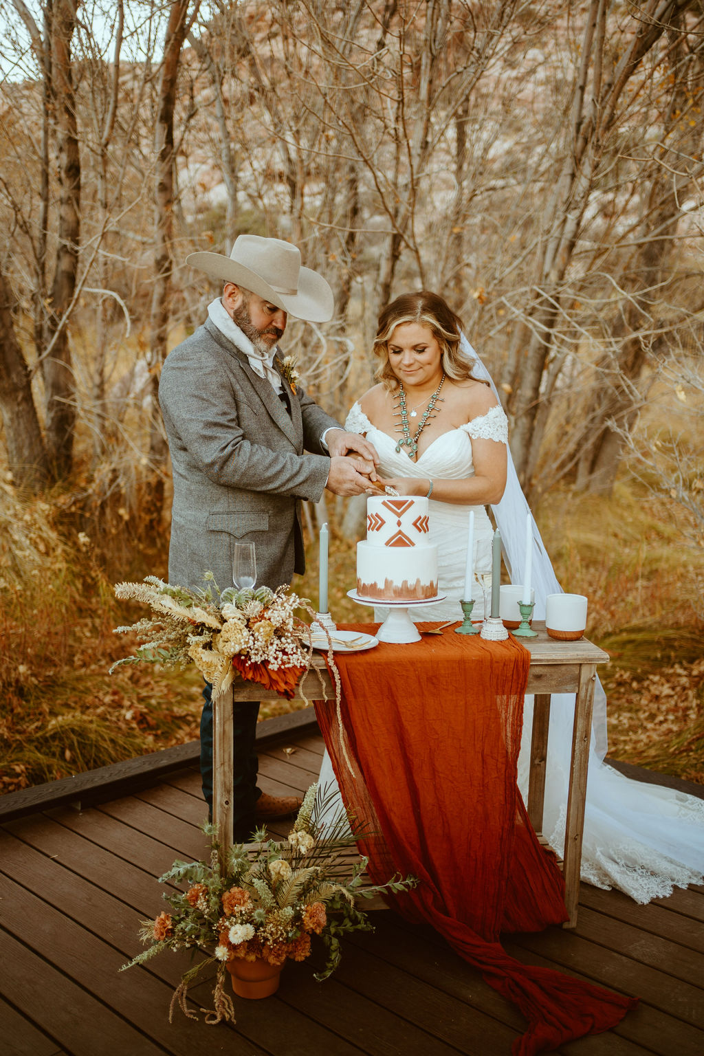 Newlyweds Cutting Cake during Western Inspired Turquoise Boho Elopement with Designed Cake Table and Dried Desert Florals 