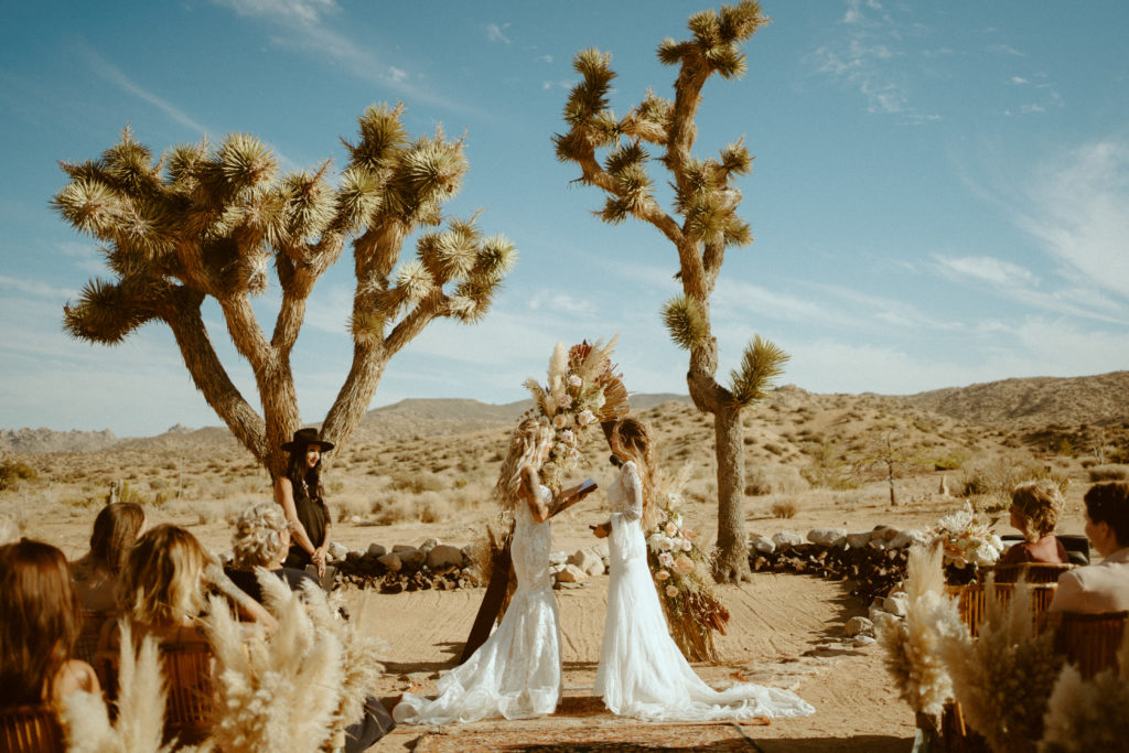 Joshua Tree Desert Boho Chic Wedding, Elopement, Microwedding, Same sex couple getting married in wedding dresses in Joshua Tree national park exchanging vows at Rim Rock Ranch
