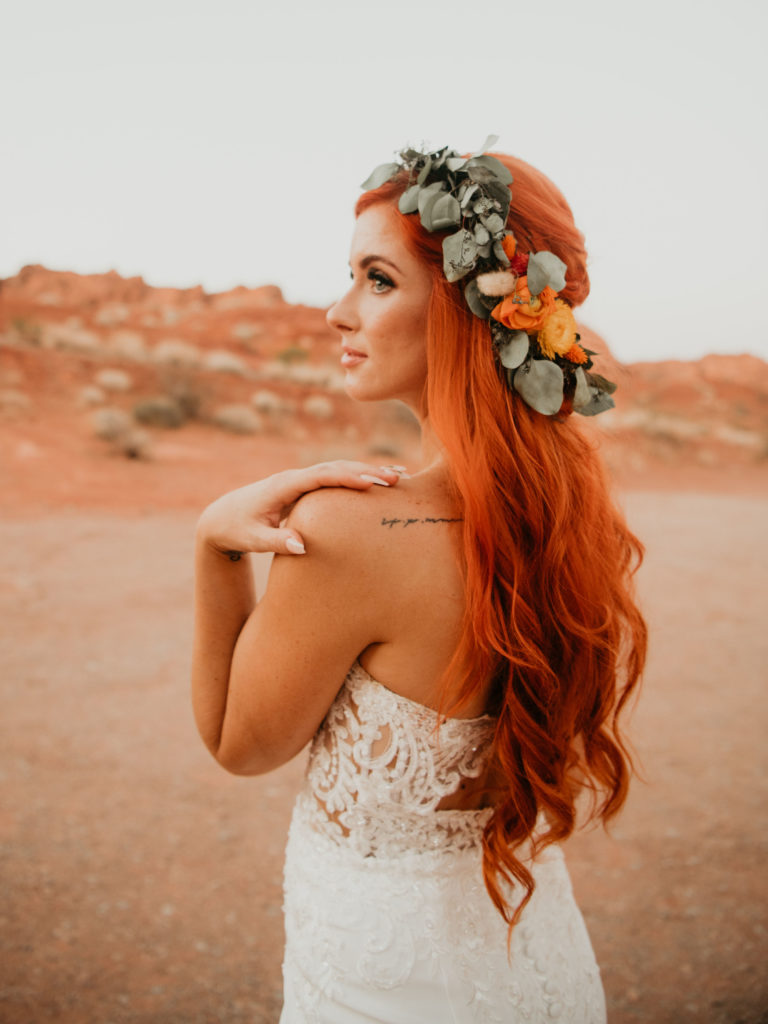 Boho bride in a greenery floral head piece with subtle hints of florals on top of her long soft curls. 