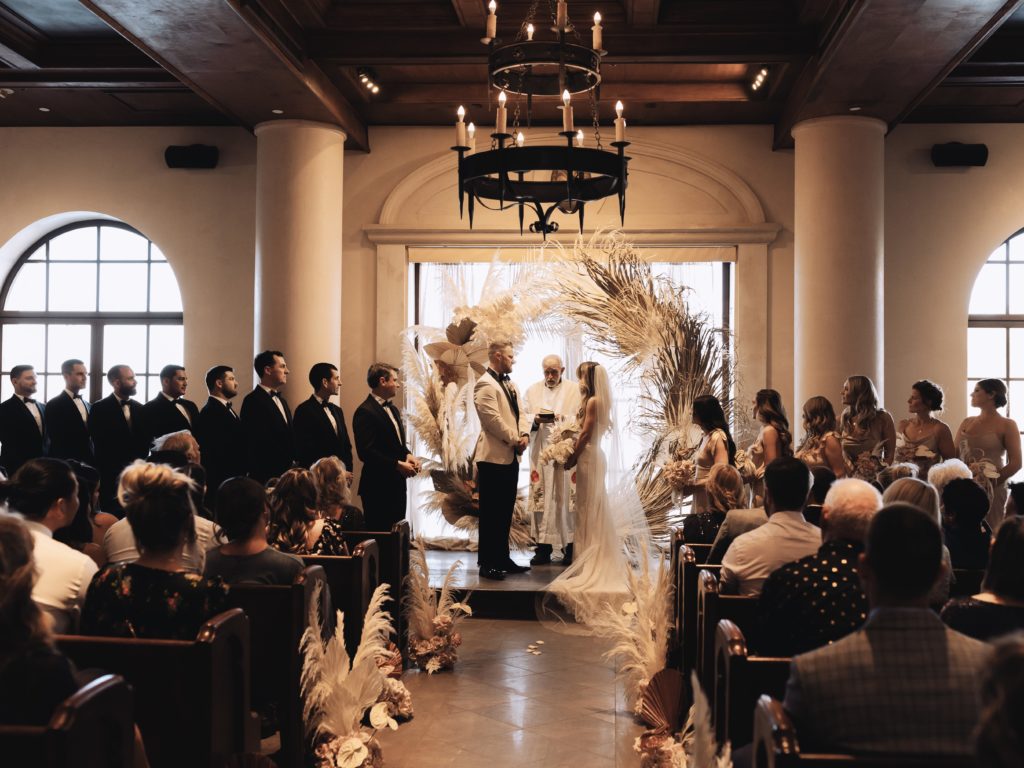 How to decide if you want an elopement or traditional wedding. Traditional wedding in the chapel of the Hilton at Lake Las Vegas. Couple standing at altar. 