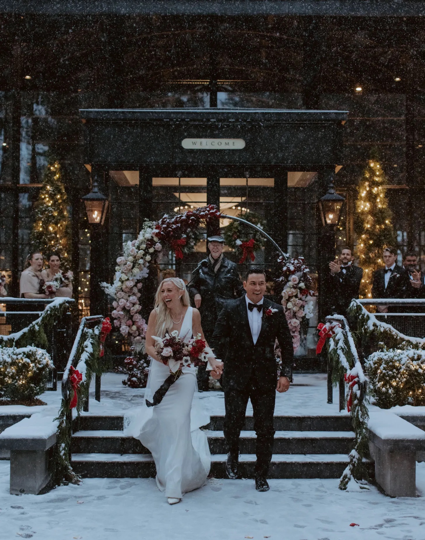 Newlyweds exiting ceremony with circle arch in the snow 