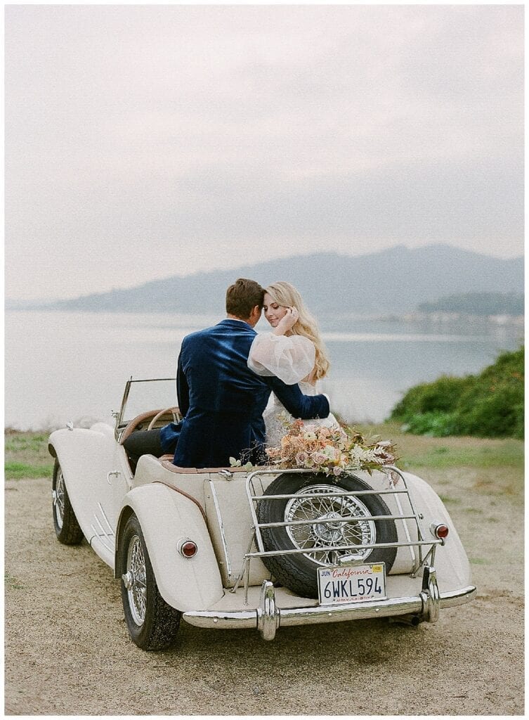 Newlywed's driving off in the coast in a vintage car