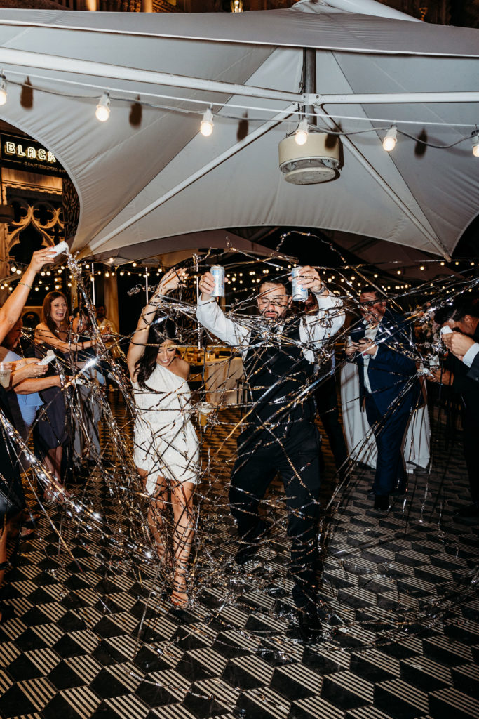 The Official List of 2023 Wedding Trends! Newlyweds make a grand exit out of the reception with streamers being popped as they walk out 