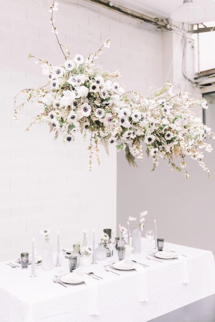 Hanging floral chandelier installation over sweetheart table