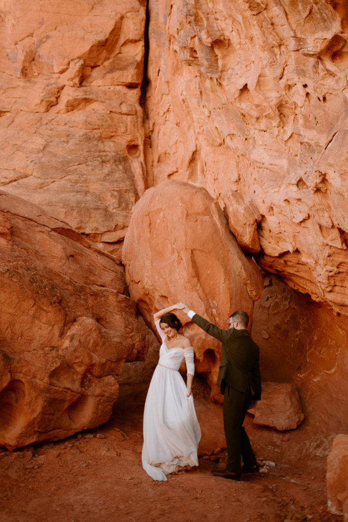 How to decide if you want an elopement or traditional wedding. Newlyweds have their first dance as a married couple in front of the red rocks of Valley of Fire