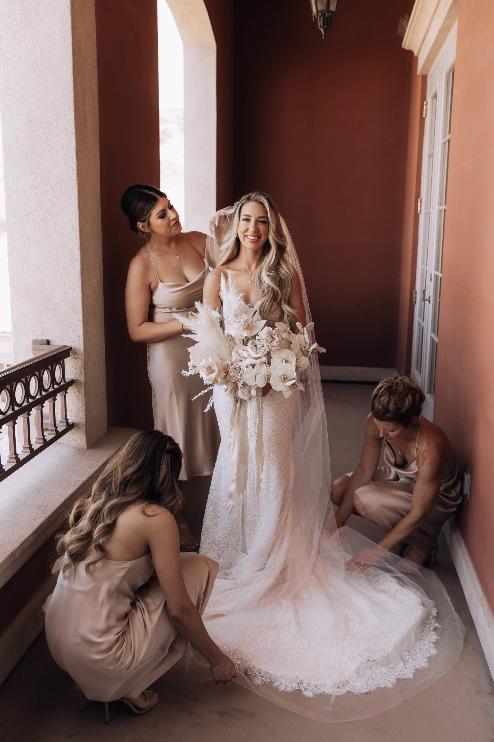 Lake Las Vegas Meets Modern Boho Bride. The bridesmaid helping the bride with her train and viel