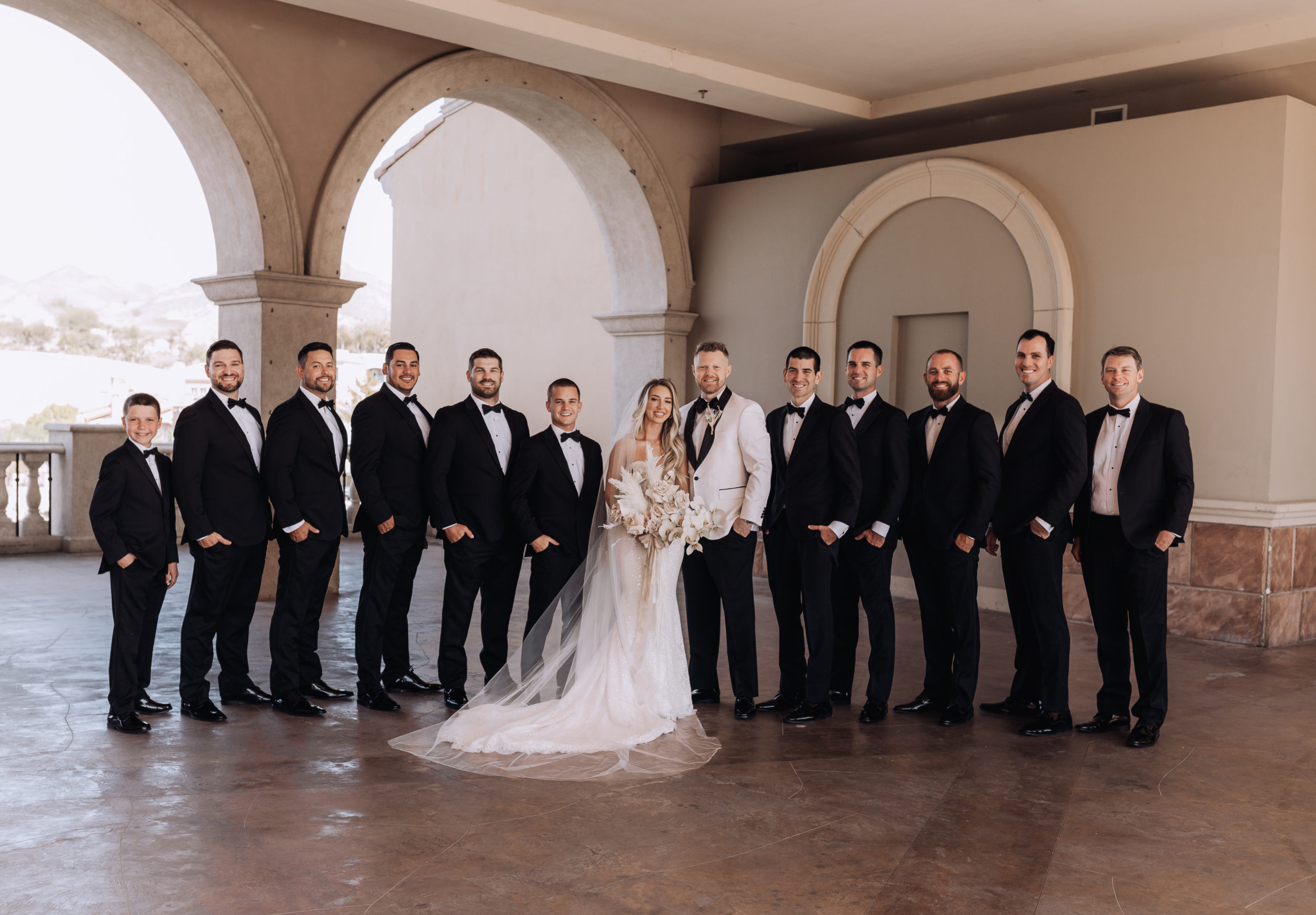 Lake Las Vegas Meets Modern Boho Bride. Newlyweds take a photo with the best man and grooms men on the bride at the Hilton at lake Las Vegas 