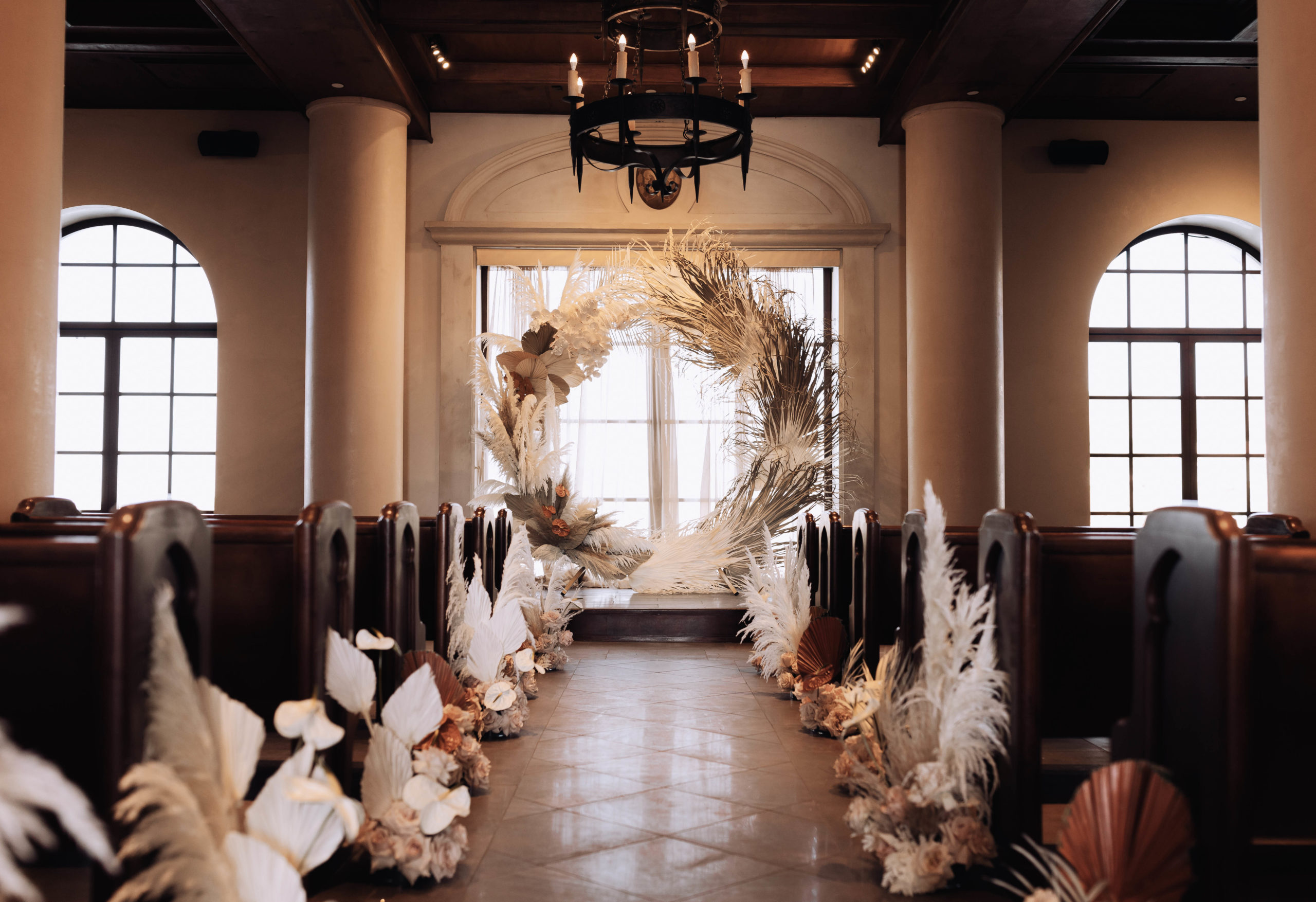 Lake Las Vegas Meets Modern Boho Bride. The Hilton of Lake Las Vegas wedding chapel. Boho circular arch covered in dried floral arrangements. Flowers placed down the aisle at every pilar.  