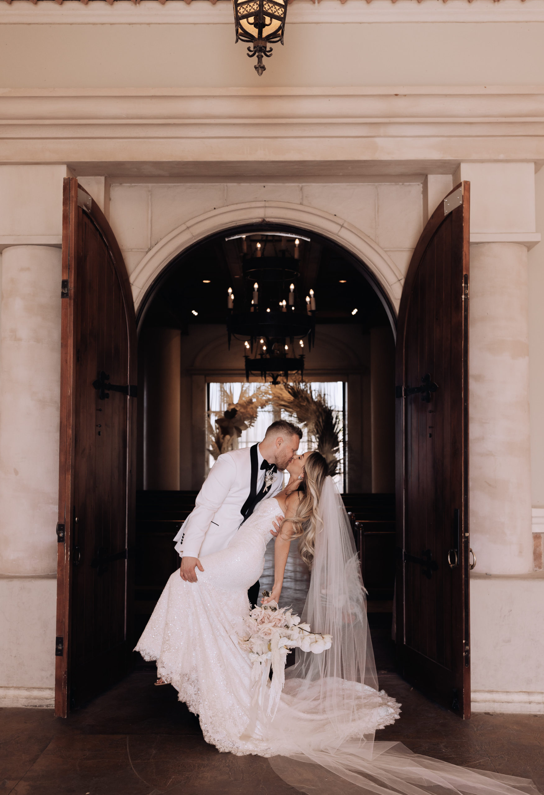 Lake Las Vegas Meets Modern Boho Bride. Newlyweds kissing in the doorway of the chapel at the Hilton of Lake Las Vegas 