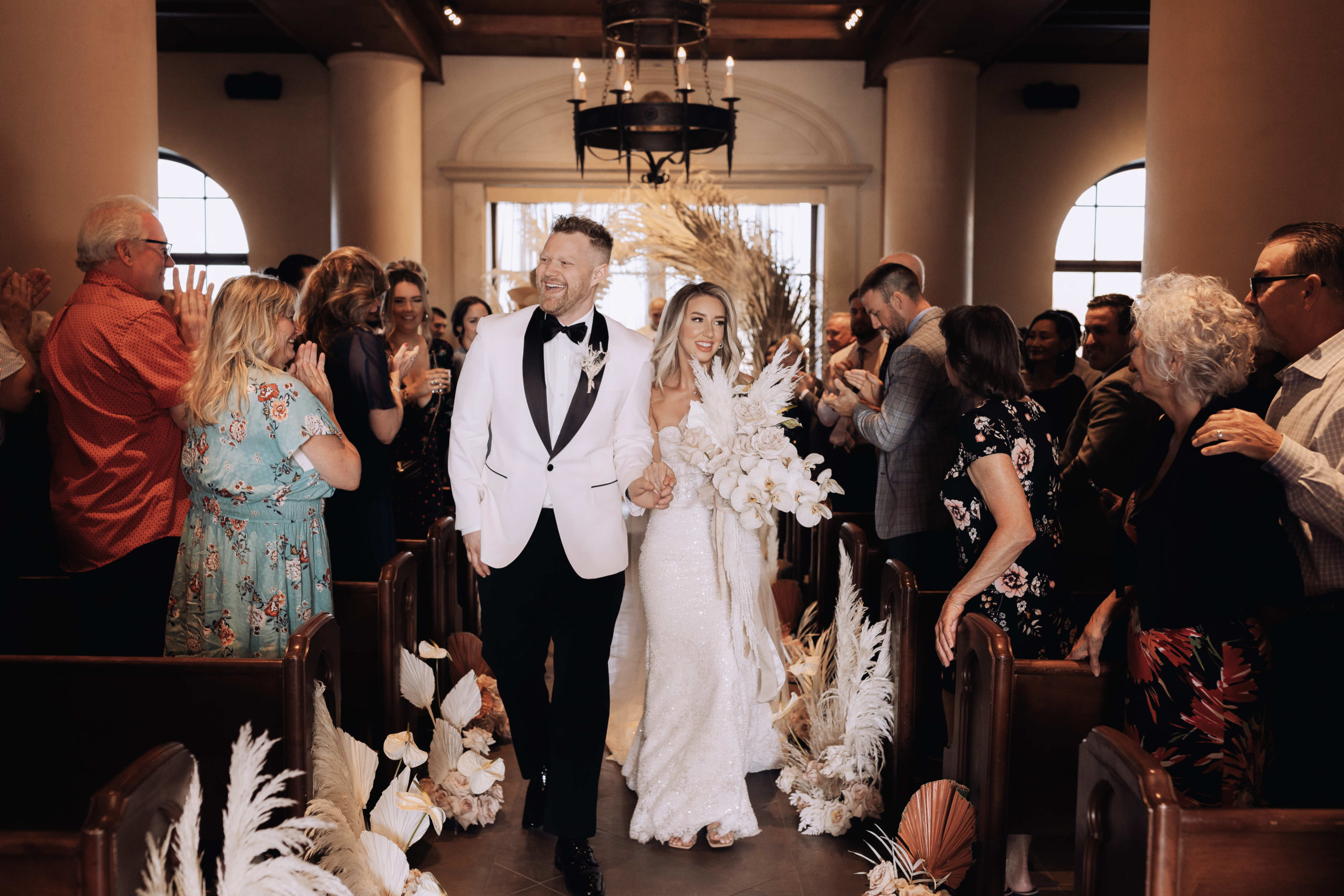 Lake Las Vegas Meets Modern Boho Bride. Newlyweds walking down the aisle of the chapel at the Hilton