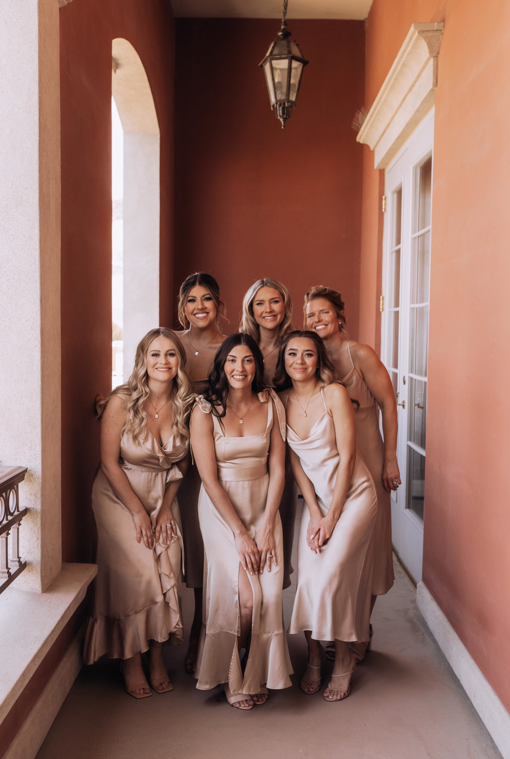 All of the bridesmaid standing on the patio of the suit waiting for the brides dress reveal 