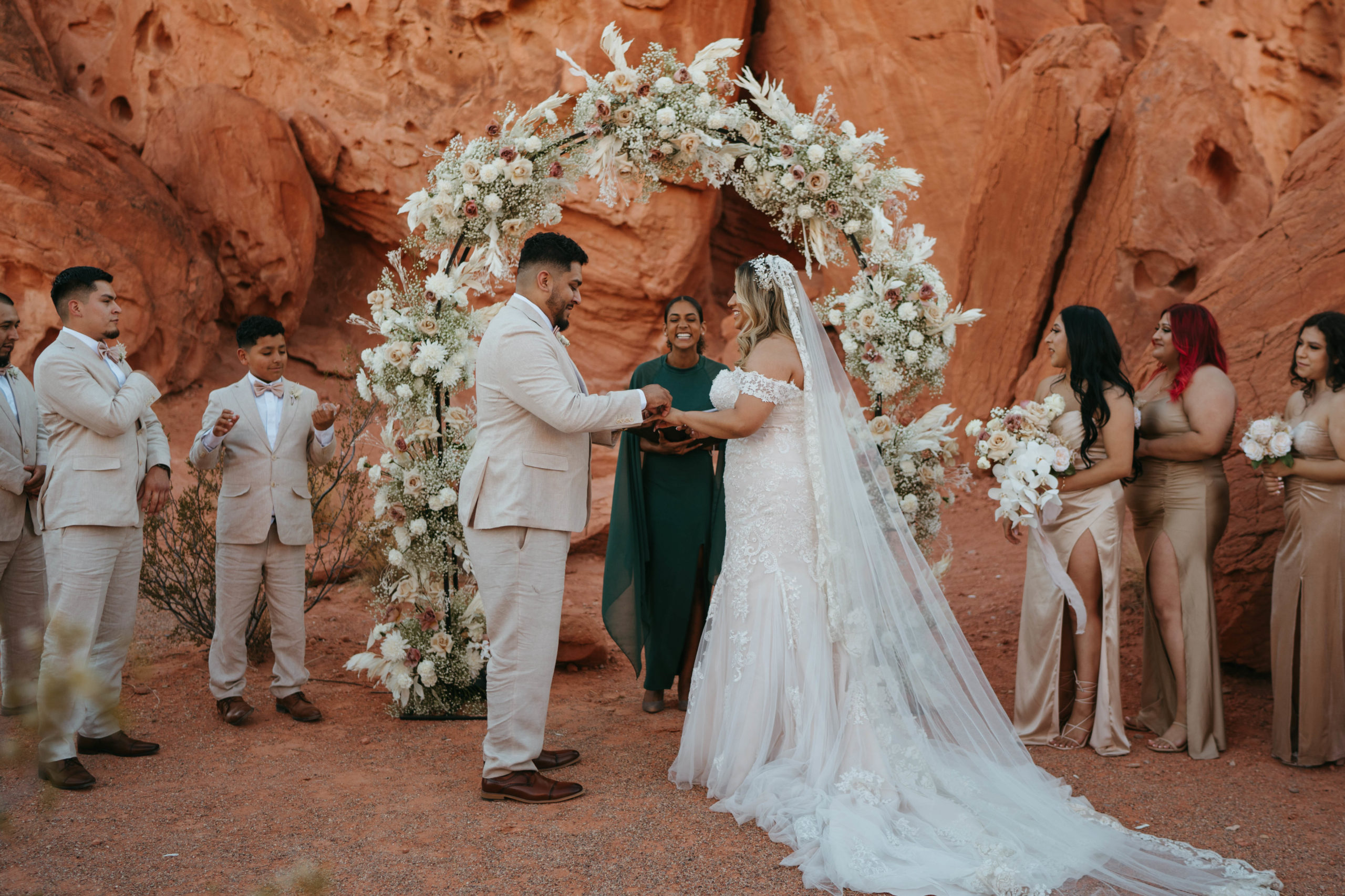 Modern Monochromatic Desert Micro-Wedding. Bride and groom exchange rings at the floral arch altar at valley of fire