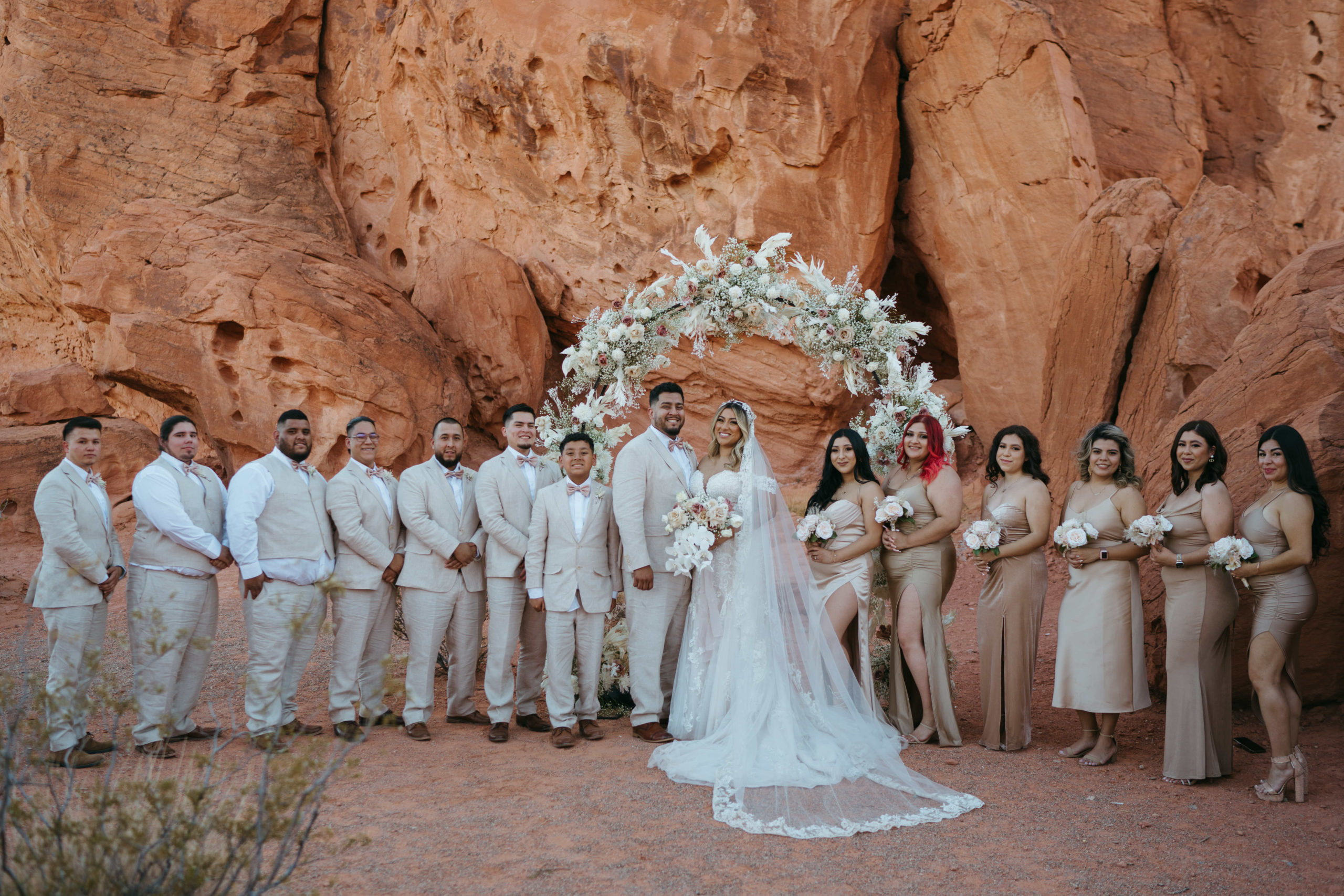 Modern Monochromatic Desert Micro-Wedding. Bride and groom stand at the circular floral covered altar with wedding party