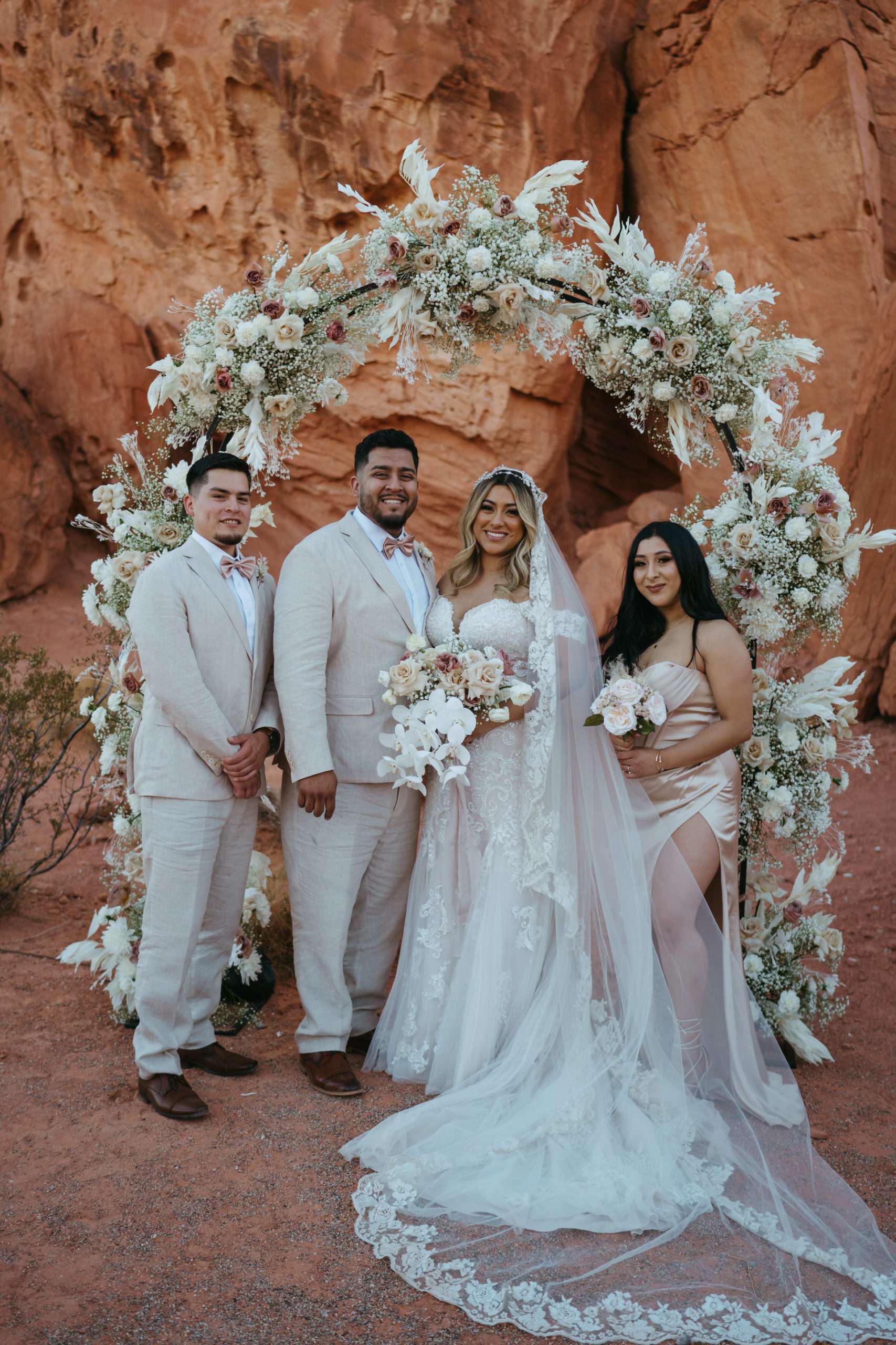 Modern Monochromatic Desert Micro-Wedding. The bride and groom take a photo with the maid of honor and best man