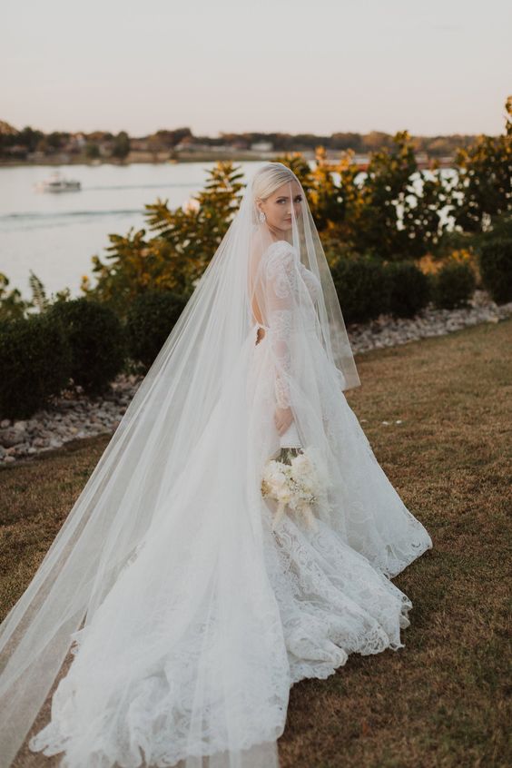 Bride walking through the garden in a chapel length wedding veil