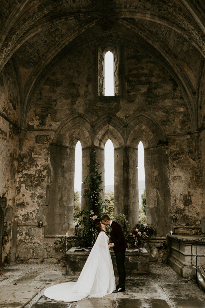 Game of Throne inspired Ireland wedding. Newlyweds kissing at the rustic altar 