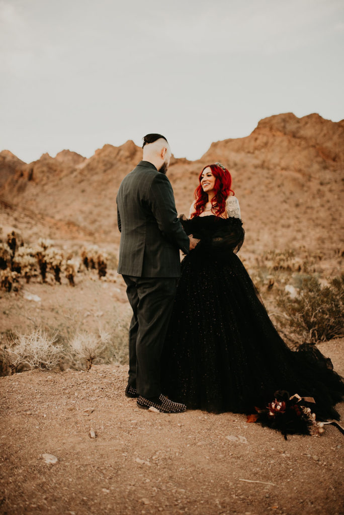 Couple giving vows for Halloween Elopement at Nelson's Ghost Town with Mountains in the back 