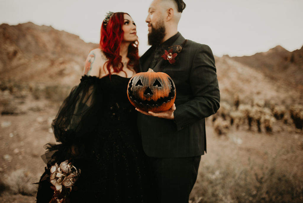 Bride and Groom holding spray painted pumpkins for Halloween Elopement at Nelson's Ghost Town