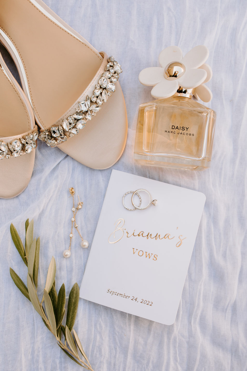 Brides custom white and gold vow book with bridal shoes and perfume for wedding details 