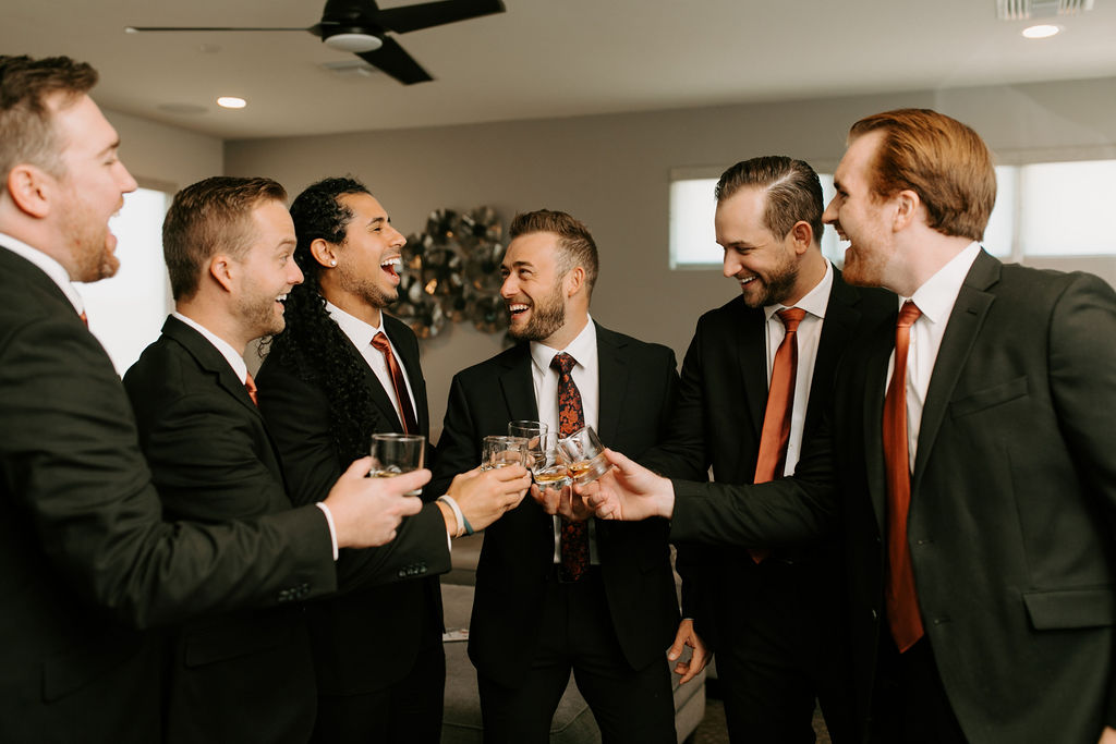 Wedding party with burnt orange ties doing a cheers with custom glasses for Romantic Desert & Backyard Micro-Wedding