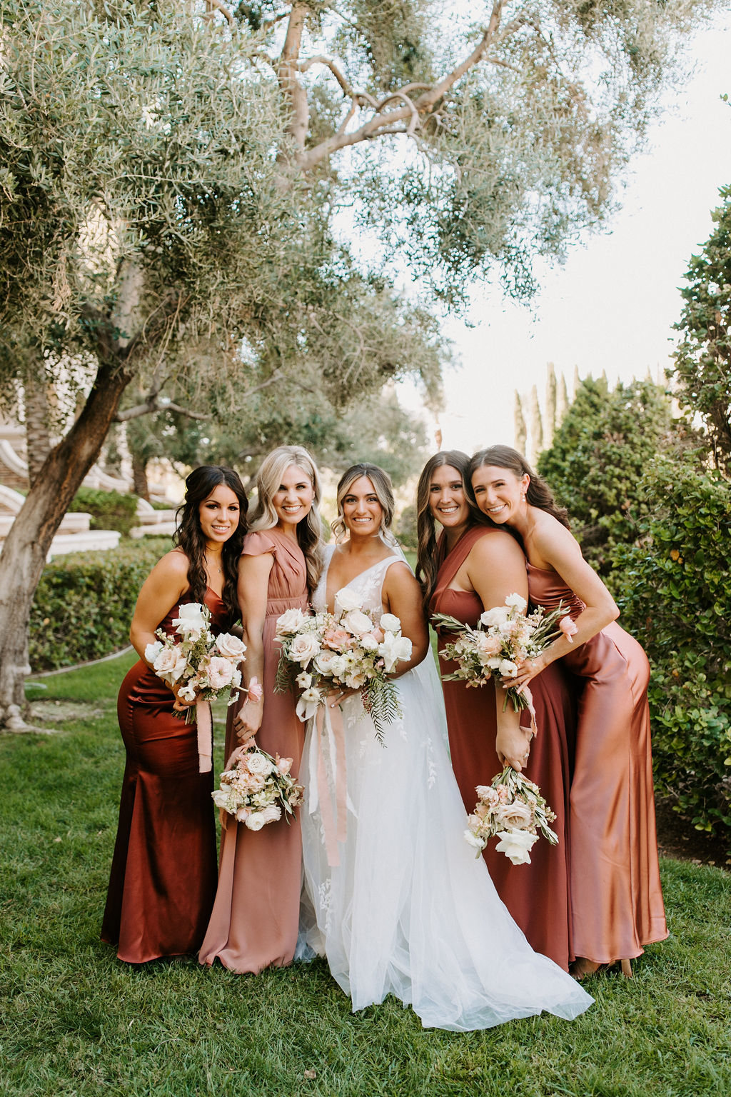 Bride and Wedding party in mauve, dusty rose, dusty rust, and rust bridesmaid dresses 