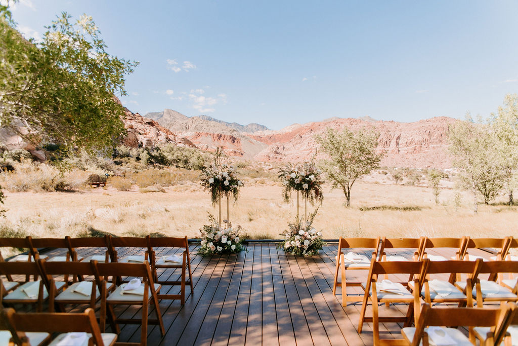 Whimsical Ceremony Decor with Harlow Stands and Soft Pink & Sage Floral with Red Rock Canyon in the background for Romantic Desert & Backyard Micro-Wedding 