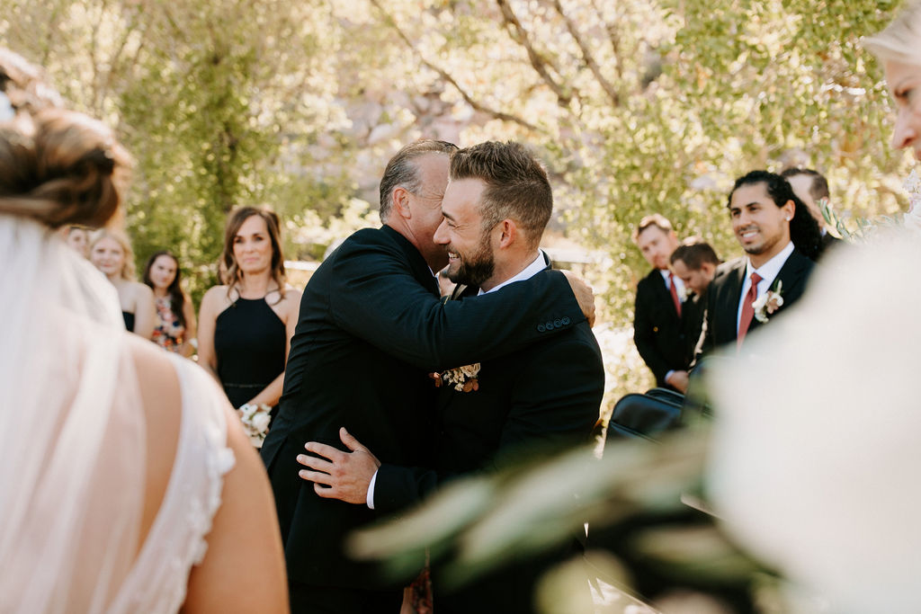 Fathering hugging groom before wedding ceremony 