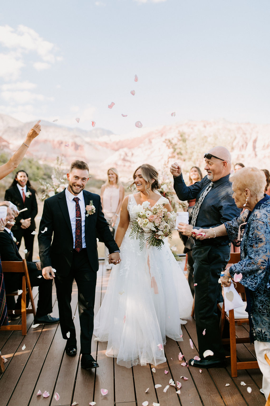 Bride and Groom walking down the aisle after getting married and rose petals being thrown for Romantic Desert & Backyard Micro-Wedding
