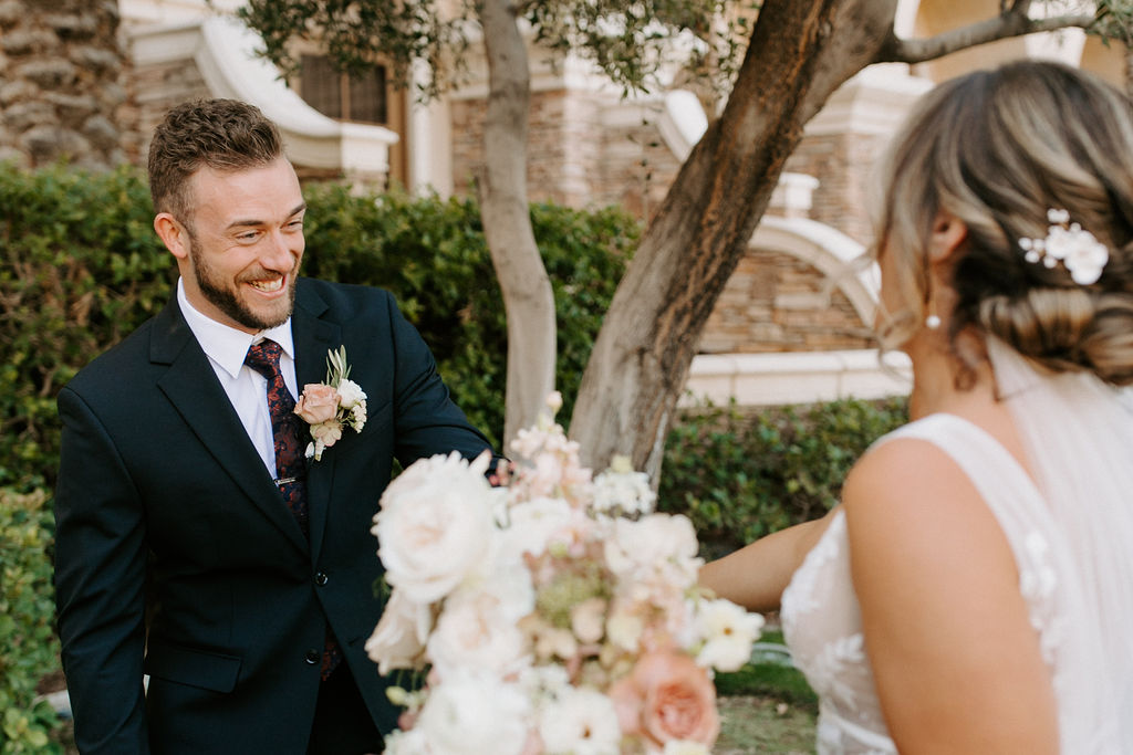 Groom smiling reacting to bride for first look 