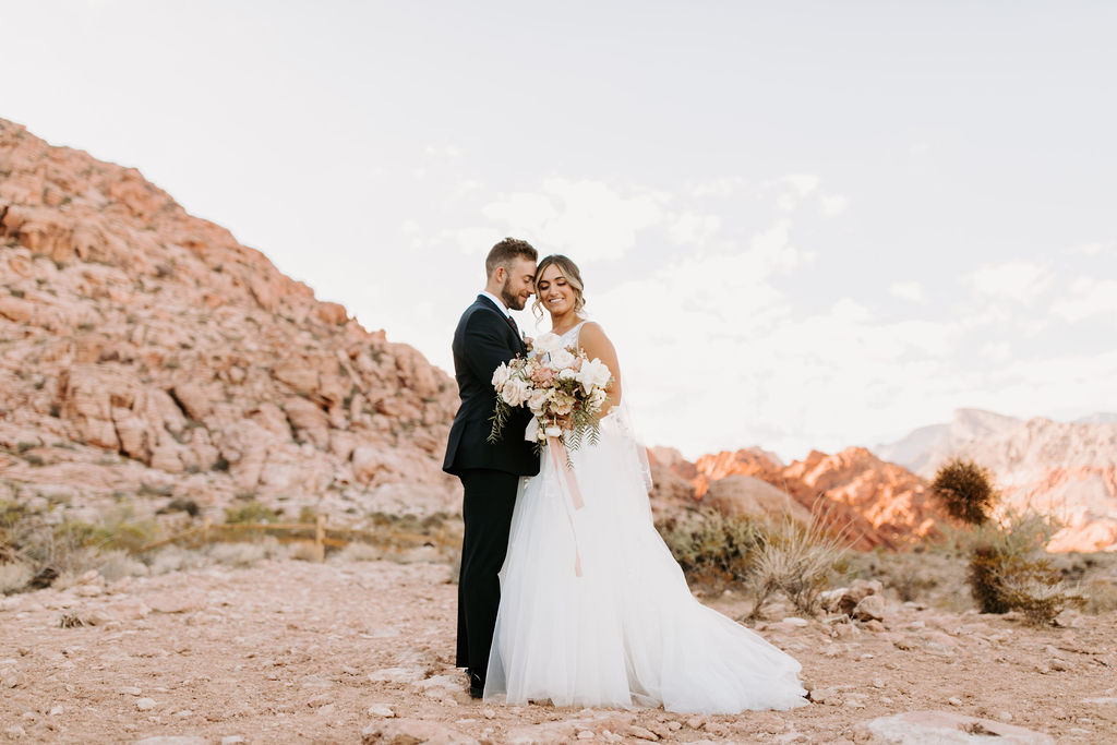 Groom leaning forehead on bride with Calico Basin Rocks in the back for Romantic Desert & Backyard Micro-Wedding