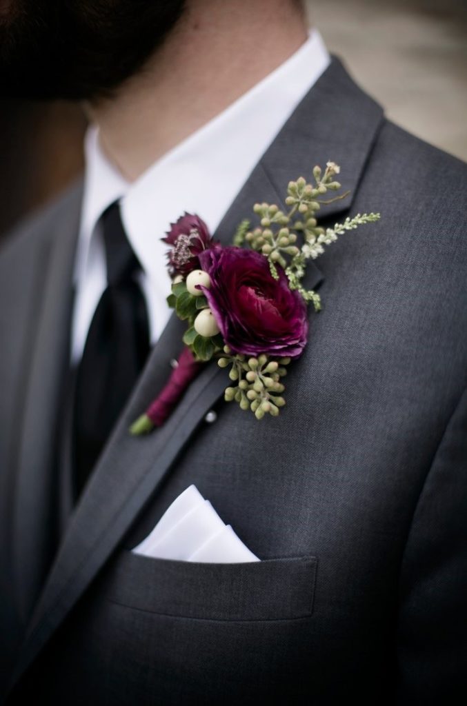 The Color of 2023 Viva Magenta! Groom wearing a hue of magenta boutonniere pinned to his suit. 