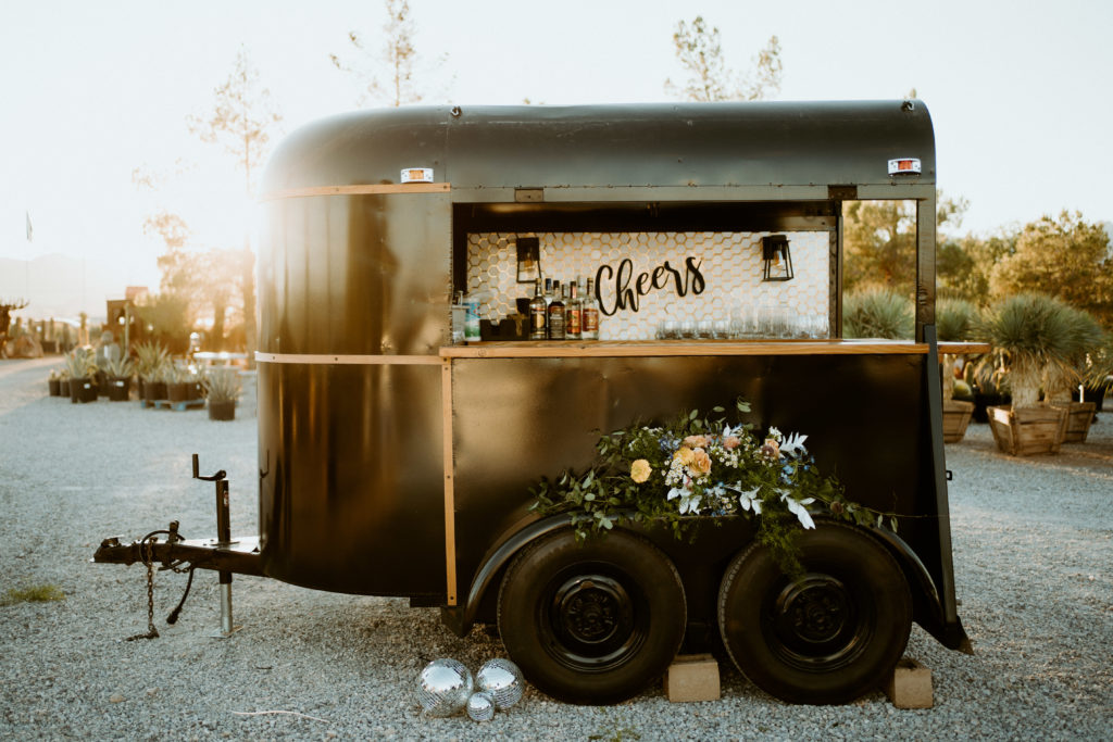 The Ultimate Wedding Timeline. Black bar cart decked out with florals and disco balls for an outdoor wedding reception. 