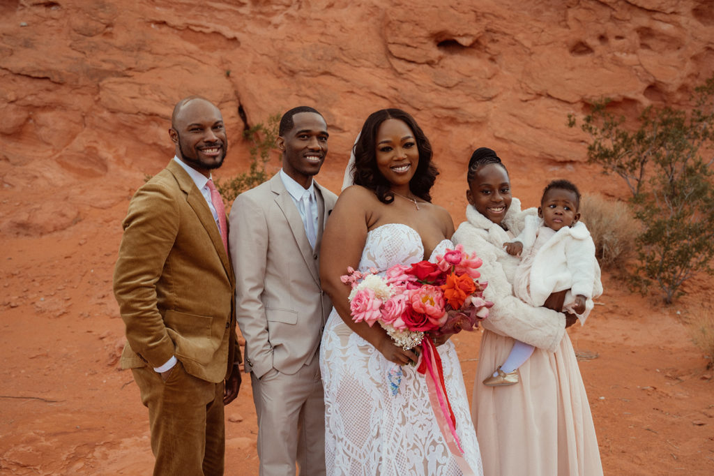 Newlyweds pose for a family photo with their two kids and best man