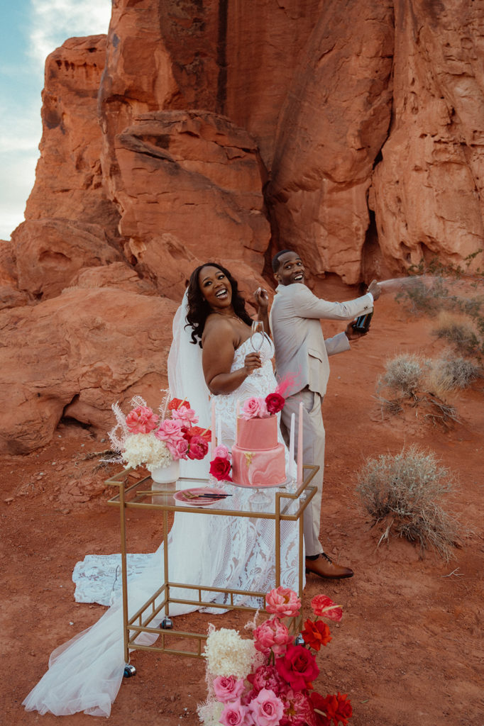 Bold & Colorful in the Vegas Desert. Newlyweds spray champagne 