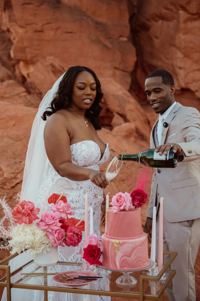 Bold & Colorful in the Vegas Desert. The groom pours his bride a glass of champagne to toast 