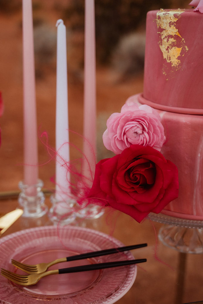 Bold & Colorful in the Vegas Desert. magenta theme cake tablescape with a magenta cake plate and gold & black trimmed silverware and an up-close look at the two tier magenta cake with gold specks
