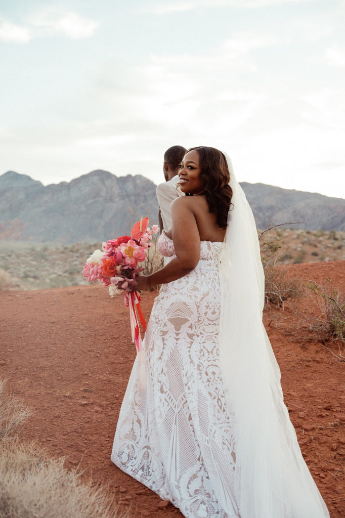 Bold & Colorful in the Vegas Desert. The Newlyweds walk into the desert as the bride stops to take a look back 