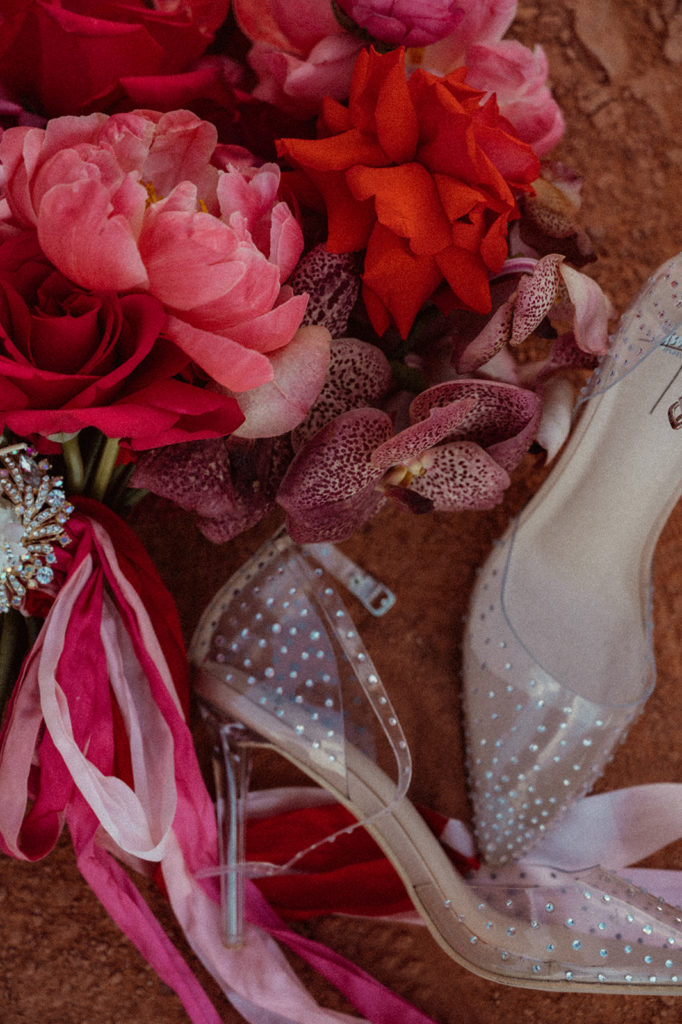 Bold & Colorful in the Vegas Desert. Wedding detail shot of the brides wedding day shoes next to her monochromatic magenta wedding bouquet 