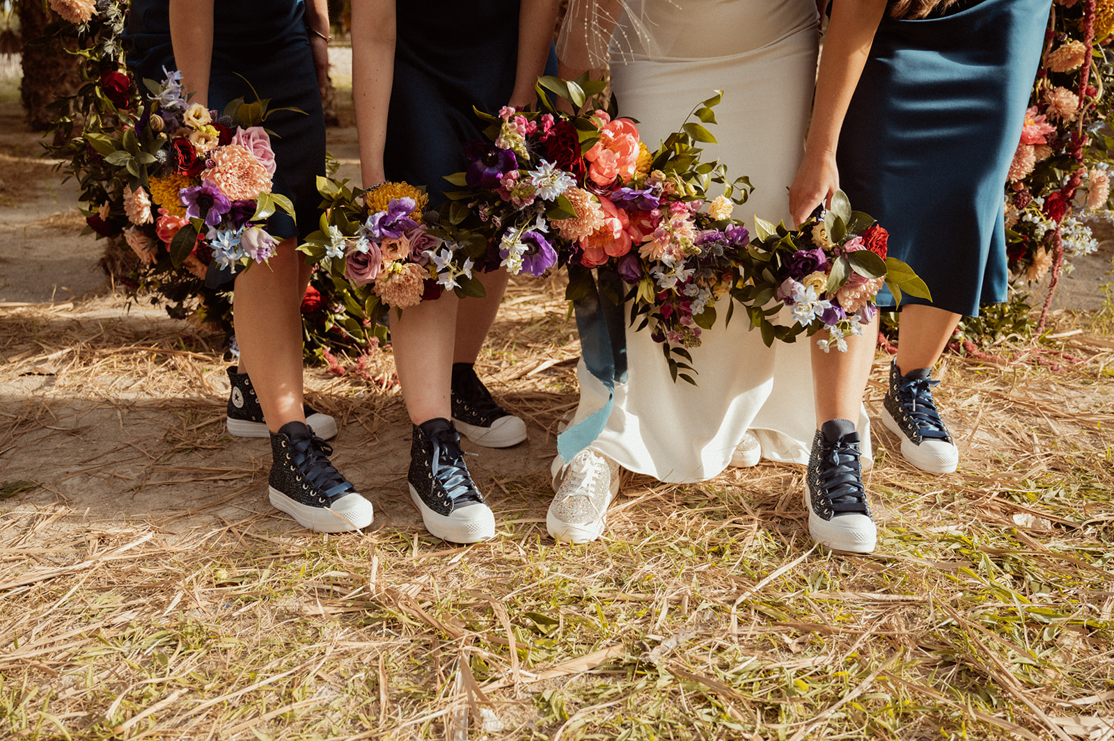 Bold Jewel Toned & Iconic Wedding bridesmaid bouquets while showing their jewel tone and sparkly tennis shoes 