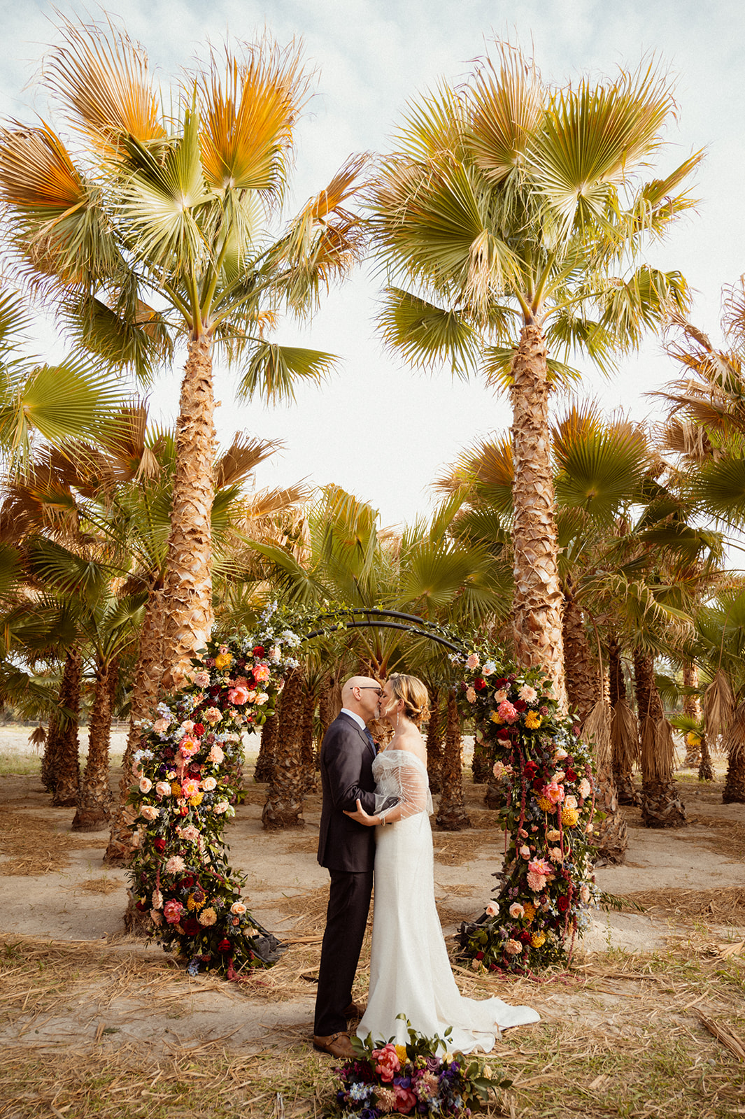 Newlyweds kissing in front of Bold Jewel Toned & Iconic Wedding Circle Arch 