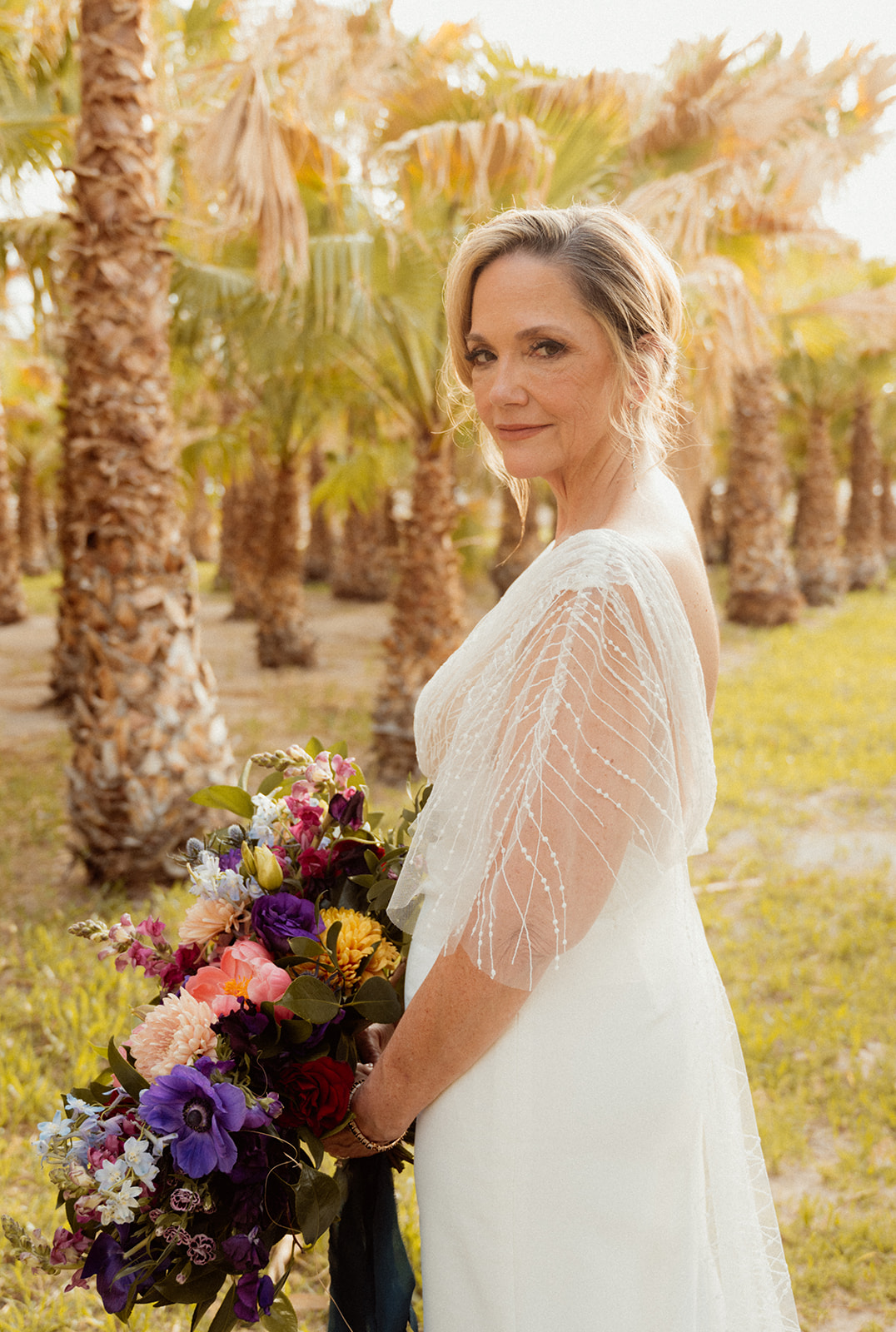 Bride with Bold Jewel Toned & Iconic Wedding Bouquet and Palm trees in the back 
