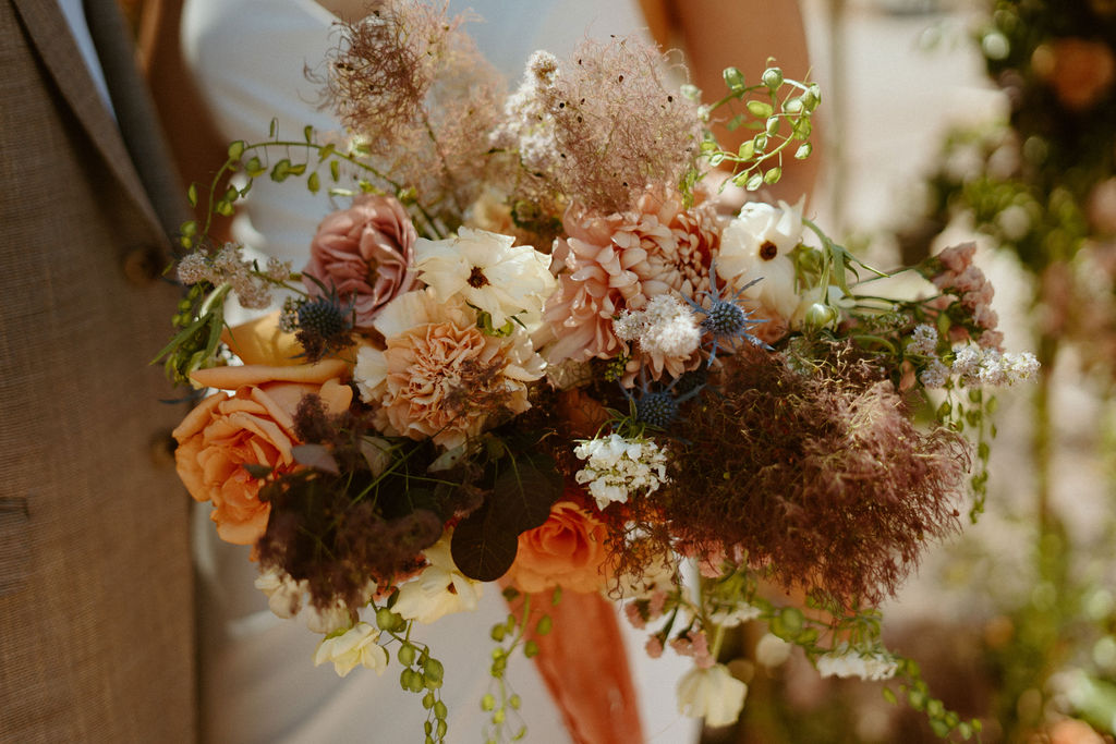 Bouquet with blush, salmon, deep red florals  