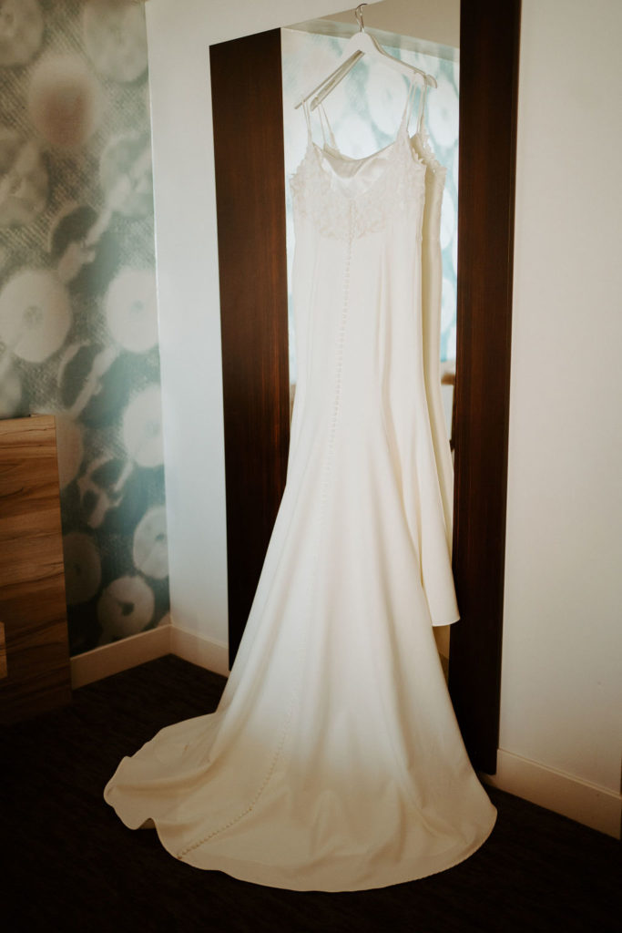 Bridal gown hanging up in hotel room