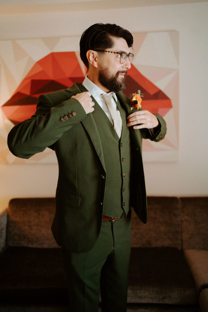 Groom getting ready with dark green wedding suit 