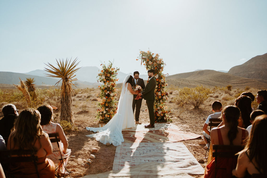Fall inspired desert marriage ceremony in Las Vegas at Cactus Joes with rug and ceremony florals 