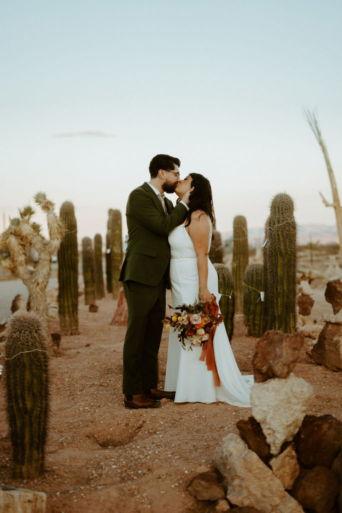 Newlyweds kissing in cactus garden 