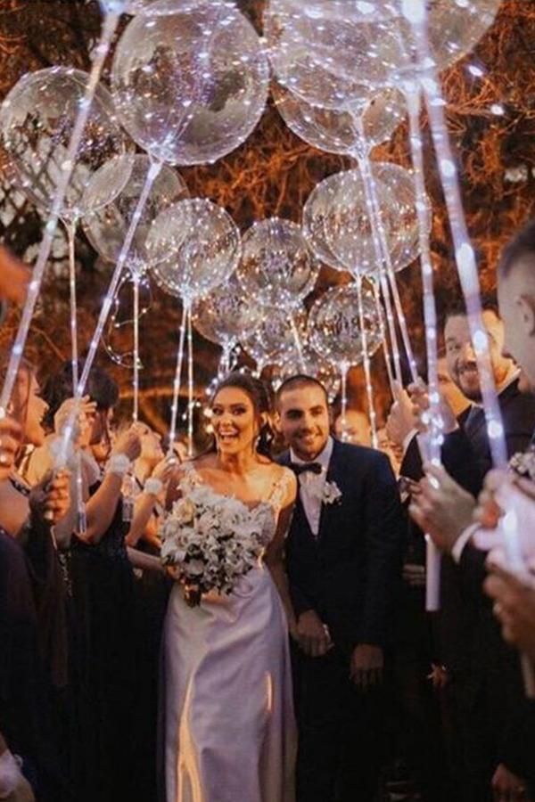 Grand exit ideas. The bride and groom make their way down an LED balloon aisle as they leave the reception