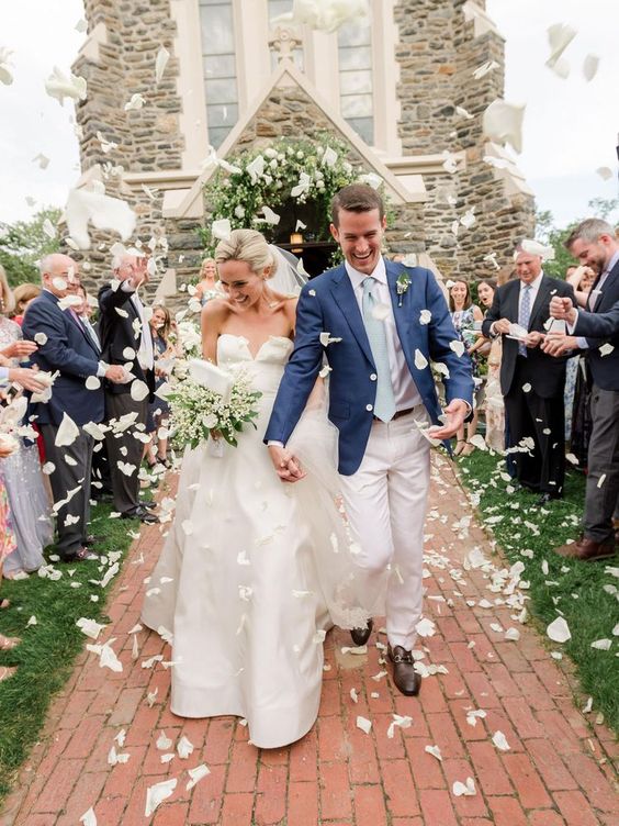 Grand exit ideas. Guest throw white rose pedals at the newlyweds as they make their way down