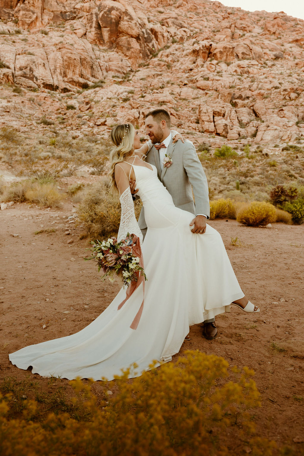 Red Rock Desert & Neon Vegas Lights. Newlyweds pose for a fun semi dip photo in the desert 