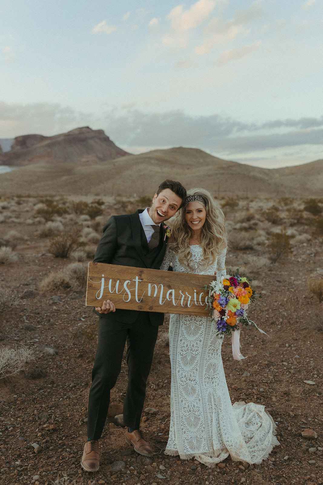 Newlyweds hold a custom wooden just married sign